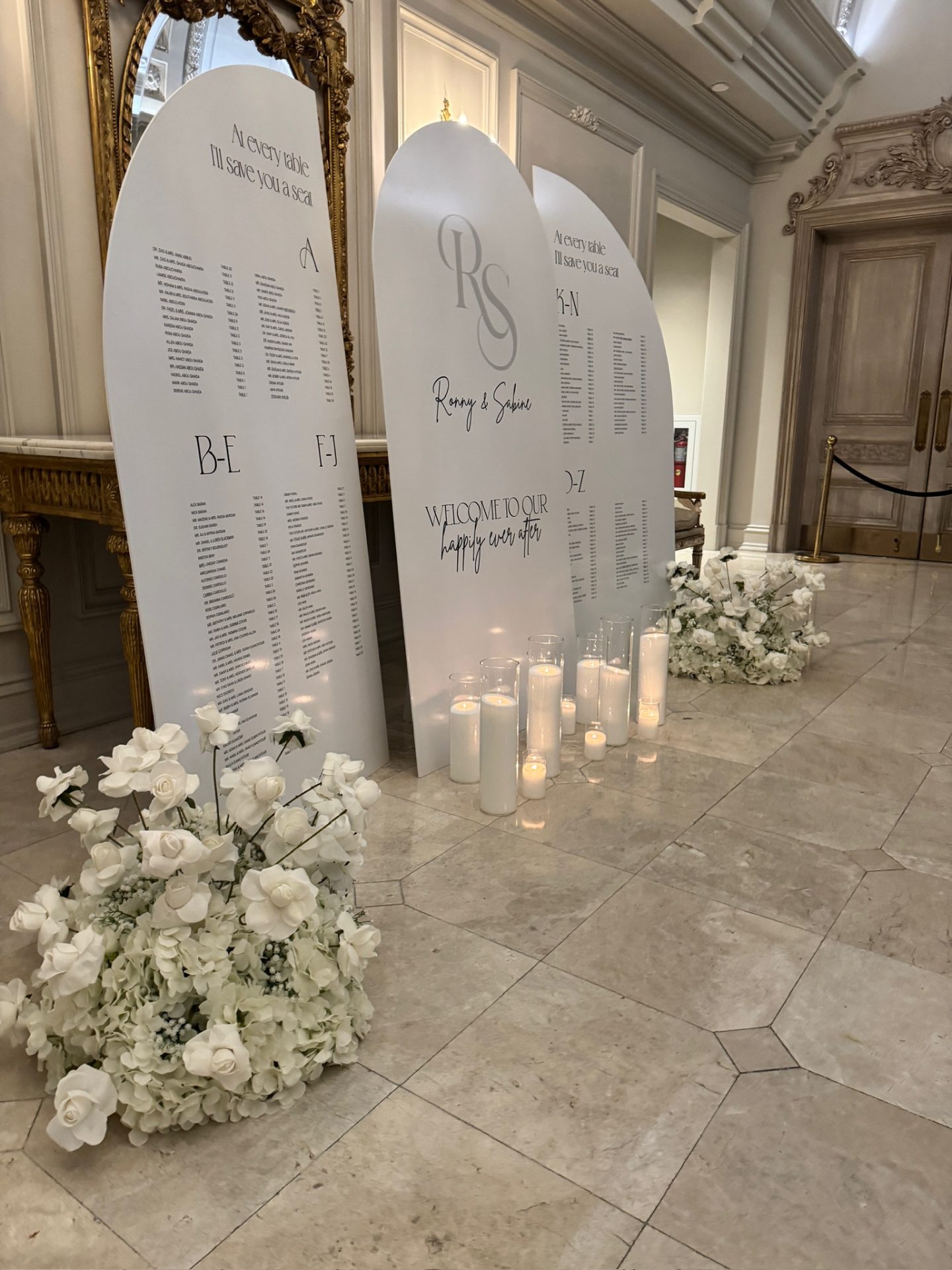 Arched seating chart boards with white floral ground installations — Park Chateau