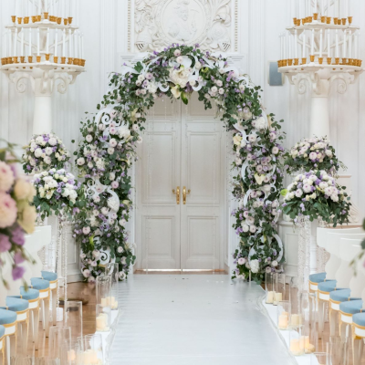 Elegant indoor wedding aisle with a floral arch and lush arrangements by Let’s Bloom Florist in Westchester, New York.